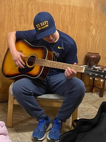 CMFCAA Trevor a teen in residential state care playing guitar for the EFF team.