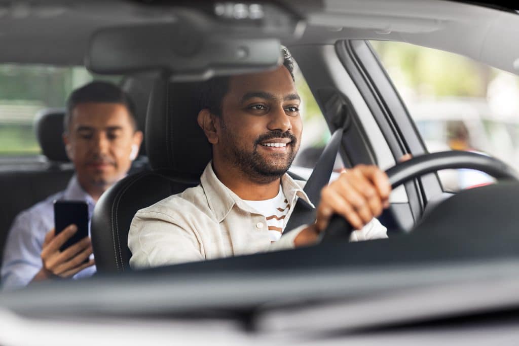 transportation, vehicle and people concept - happy smiling indian male driver driving car with passenger